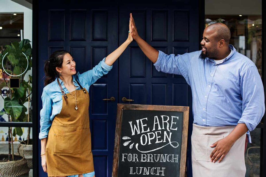 bistro restaurant owners high fiving to celebrate opening
